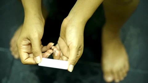 Anonymous female nervously checking a pregnancy test Asian Woman Holding Stock Footage 265934499