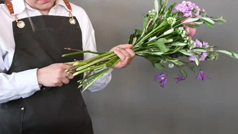 Anonymous florist cutting stems of flowers with secateurs in studio Stock Footage 252631764