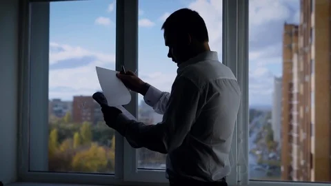 Anonymous formal man in office reading carefully file with documents Video stock 81568877