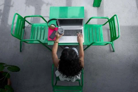 Anonymous freelancer with drink to go browsing laptop Stock Photos