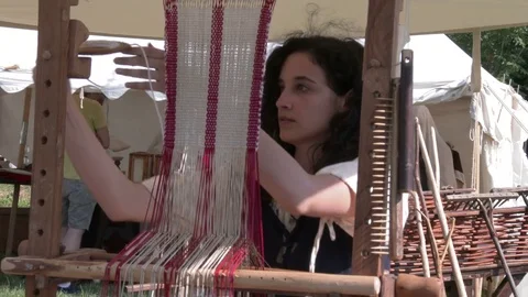 Anonymous girl performs a weaving demonstration at the loom in a medieval camp. Stock Footage 76170033