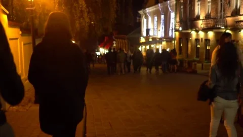 Anonymous group of friends walk through the crowded night city street. Minsk Stock-Footage 69174910