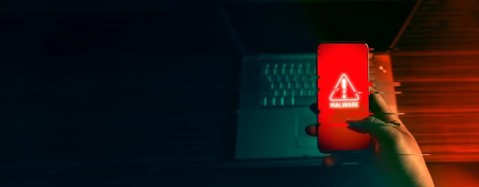 An anonymous hacker and uses a malware with mobile phone to hack password the Stock Photos