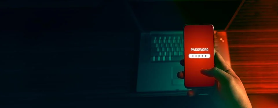 An anonymous hacker and uses a malware with mobile phone to hack password the Stock Photos