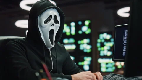 Anonymous hacker breaking data servers at night room closeup. Man looking camera 動画素材 260242920