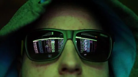 Anonymous Hacker in Dark Glasses Looking at Computer Screen Code Reflections Foto stock