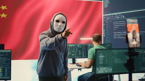 Anonymous hacker expert in a Chinese hacking high tech office Stock Photos