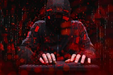 Anonymous hacker in hood typing on computer keyboard with red digital inter.. Stock Photos