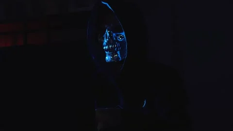 Anonymous Hacker in Hoodie and Mask at Night Typing on Keyboard – Concept of Stock Footage 310553421