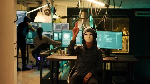 Anonymous hacker with mask using hologram to hack computer server Stock Photos