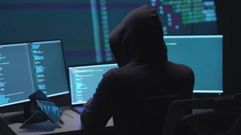 Anonymous Hacker Programming on Dual Monitors in a Low-Light Environment 動画素材 336679566