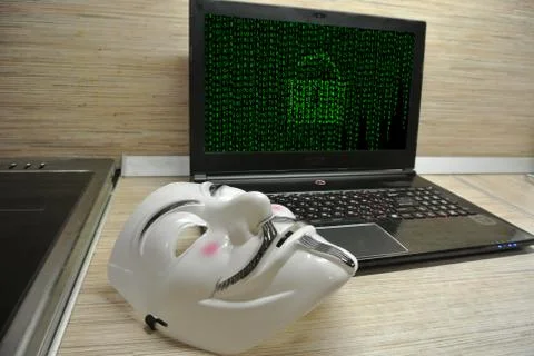 An anonymous hacker tries to crack the operating system's protection Foto stock