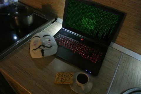 An anonymous hacker tries to crack the operating system's protection Foto stock