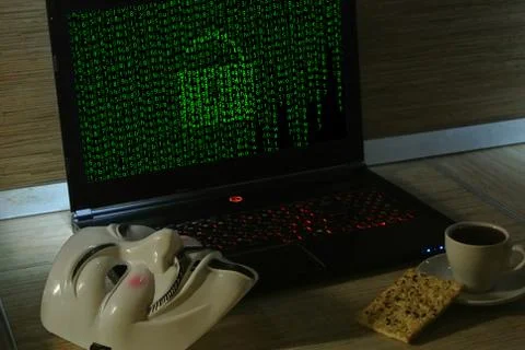 An anonymous hacker tries to crack the operating system's protection Foto stock