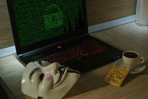 An anonymous hacker tries to crack the operating system's protection Foto stock