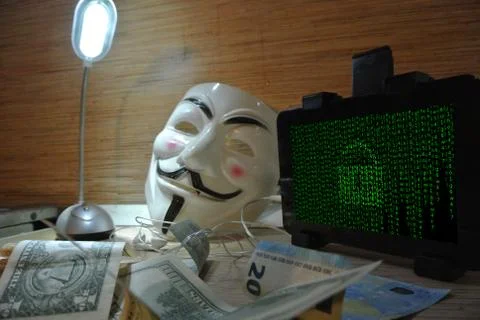 An anonymous hacker tries to crack the operating system's protection Foto stock