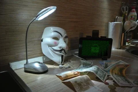 An anonymous hacker tries to crack the operating system's protection Foto stock