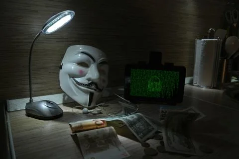 An anonymous hacker tries to crack the operating system's protection Foto stock