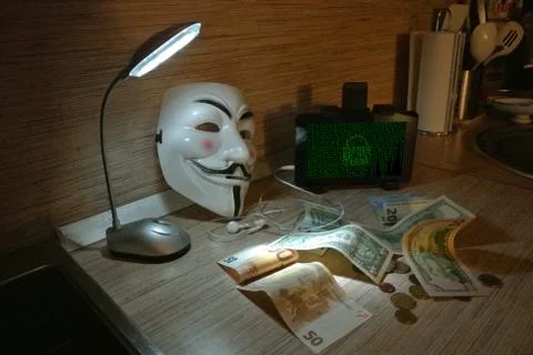 An anonymous hacker tries to crack the operating system's protection Foto stock