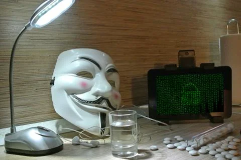 An anonymous hacker tries to crack the operating system's protection Foto stock