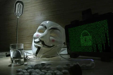 An anonymous hacker tries to crack the operating system's protection Foto stock