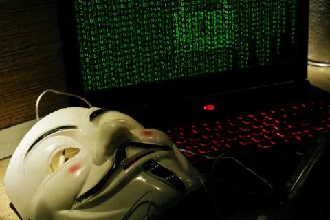 An anonymous hacker tries to crack the operating system's protection Foto stock