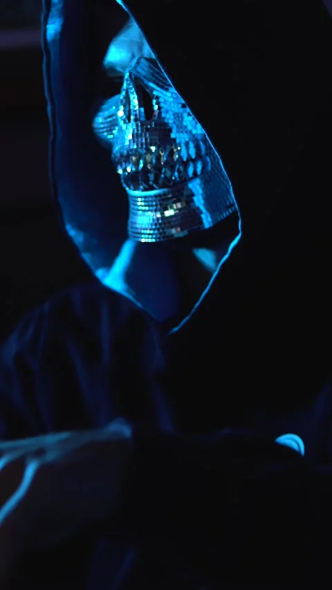 Anonymous hacker typing lines of code on laptop in dark studio for Stock Footage 310214141