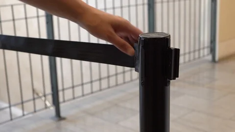 Anonymous hand opens stanchion barrier Stock Footage 114154880