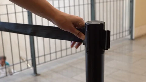 Anonymous hand ropes off stanchion Stock Footage 114154844