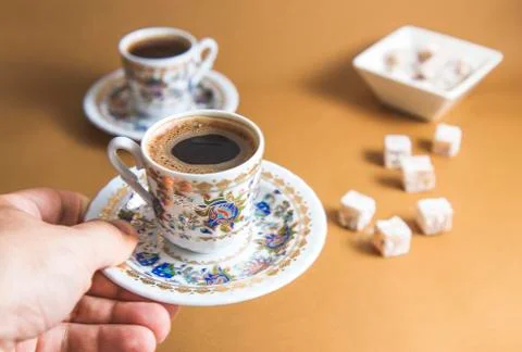 An anonymous hand is serving Turkish coffee and Turkish delight view over mon Stock-Fotos