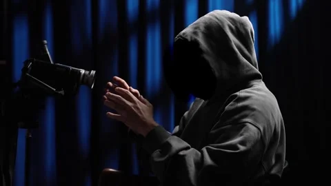 Anonymous hooded figure talking during interrogation Video stock 318179143
