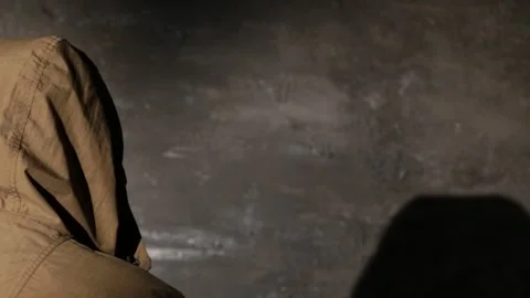 Anonymous hooded hacker with back to camera during police interrogation in .. Stock Footage 324955946