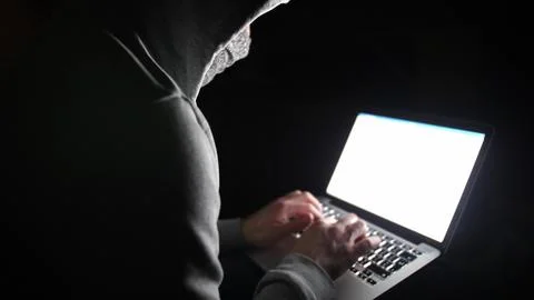 Anonymous Hooded Hacker Programming in Computer Console Breaking Password Stock Photos