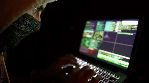 Anonymous Hooded Hacker Programming in Computer Console Breaking Password Stock Photos