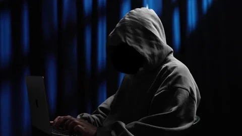 Anonymous hooded hacker programming on laptop computer Stock Footage 318297456