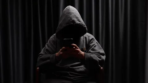 Anonymous hooded hacker using a smartphone in the dark Stock Footage 318145874