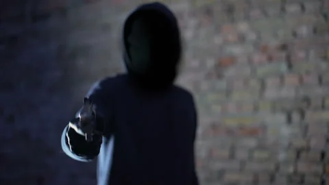 Anonymous hooligan threatening with gun, robbery aggression, armed criminal Stock Footage 94669269