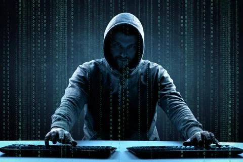 Anonymous internet hacker in front of computer. Web crime concept Stock Photos