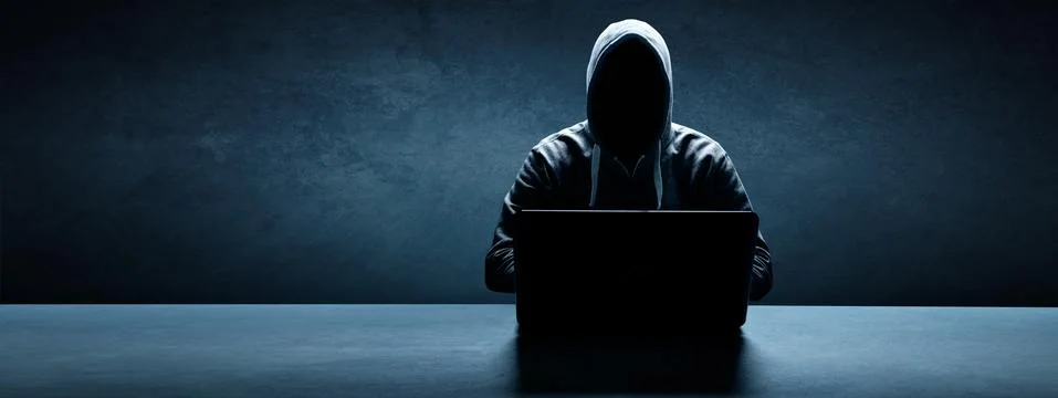 Anonymous internet hacker in front of computer. Web crime concept Stock Photos