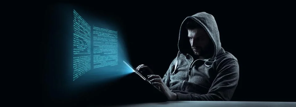 Anonymous internet hacker in front of computer. Web crime concept Stock Photos