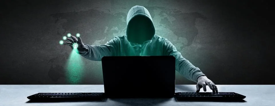 Anonymous internet hacker in front of computer. Web crime concept Stock Photos