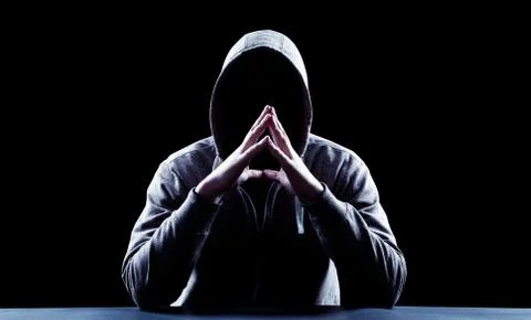 Anonymous internet hacker in front of computer. Web crime concept Stock Photos
