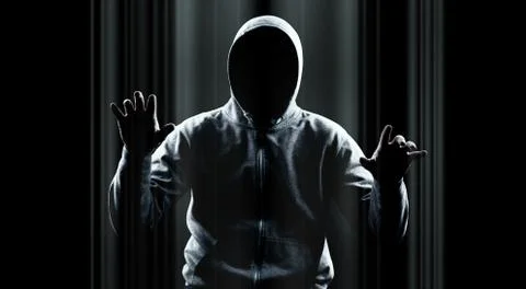 Anonymous internet hacker in front of computer. Web crime concept Stock Photos
