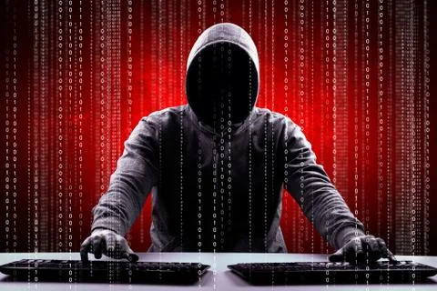 Anonymous internet hacker in front of computer. Web crime concept Stock Photos