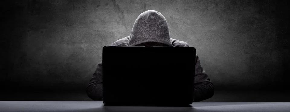 Anonymous internet hacker in front of computer. Web crime concept Stock Photos