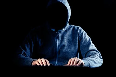 Anonymous internet hacker in front of computer. Web crime concept Stock Photos
