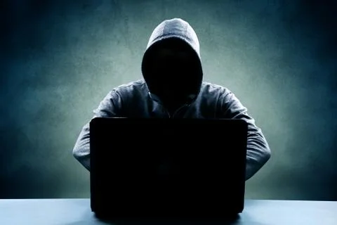 Anonymous internet hacker in front of computer. Web crime concept Stock Photos