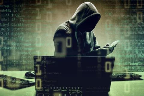 Anonymous internet hacker in front of computer. Web crime concept Stock Photos