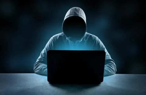Anonymous internet hacker in front of computer. Web crime concept Stock Photos