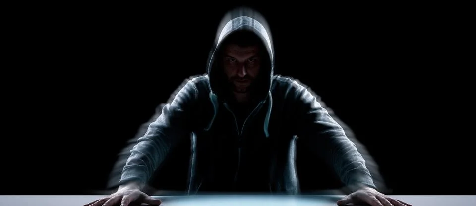 Anonymous internet hacker in front of computer. Web crime concept Stock Photos